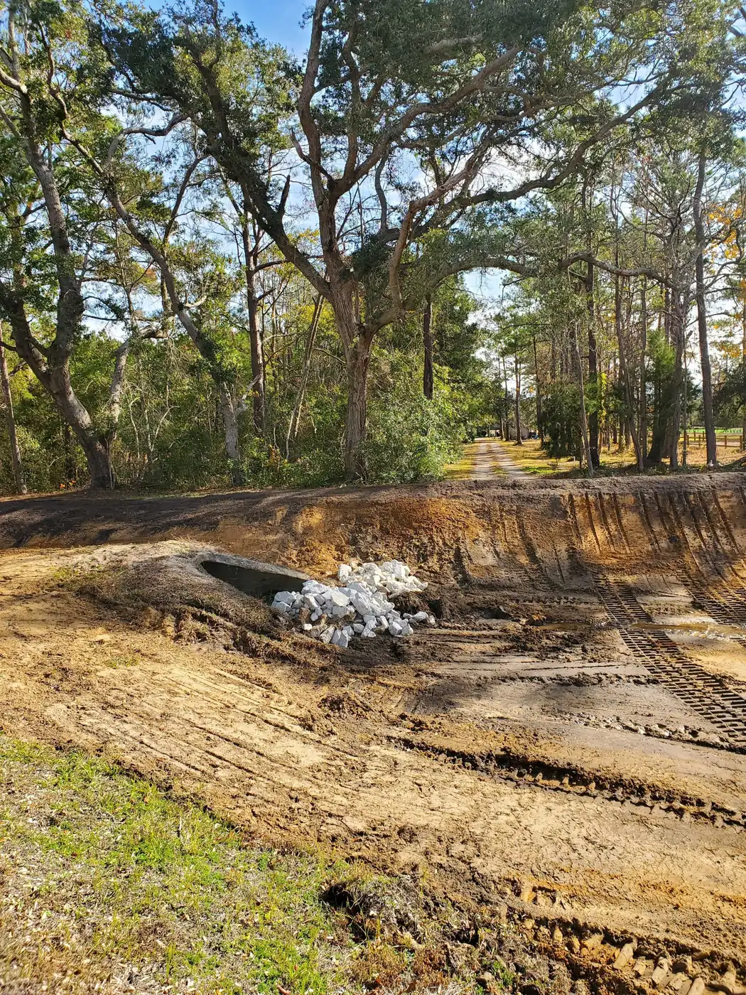 site prep cost in North Carolina, a freshly graded lot with a culvert pipe and rip-rap set at the ditch
